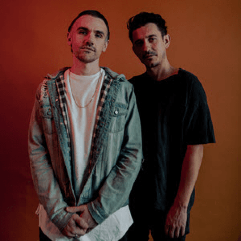 Artist duo portrait against an orange wall